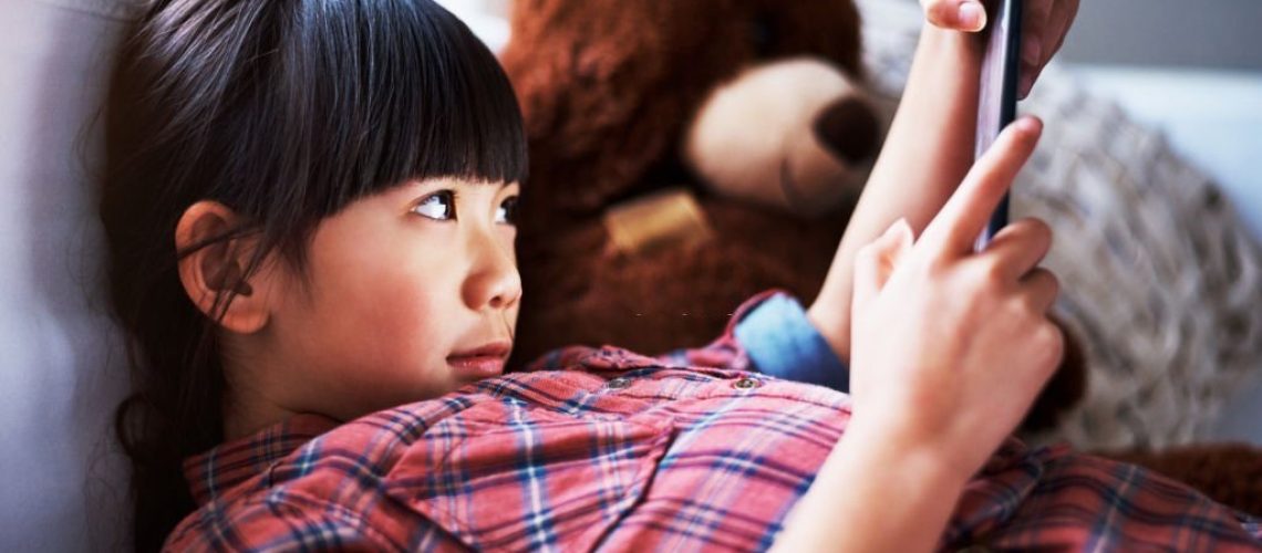 Shot of a little girl using a digital tablet at home