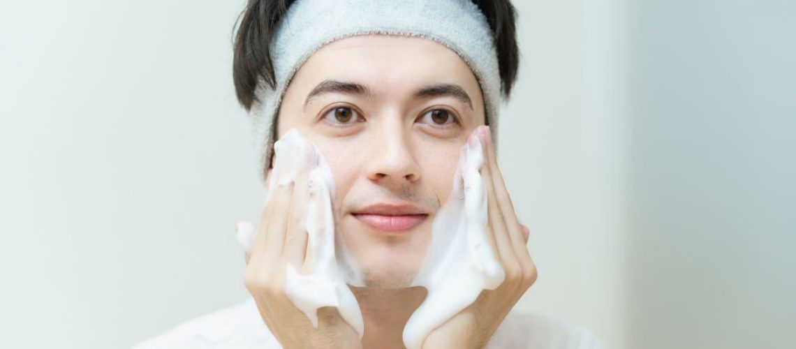 Asian young man washing his face