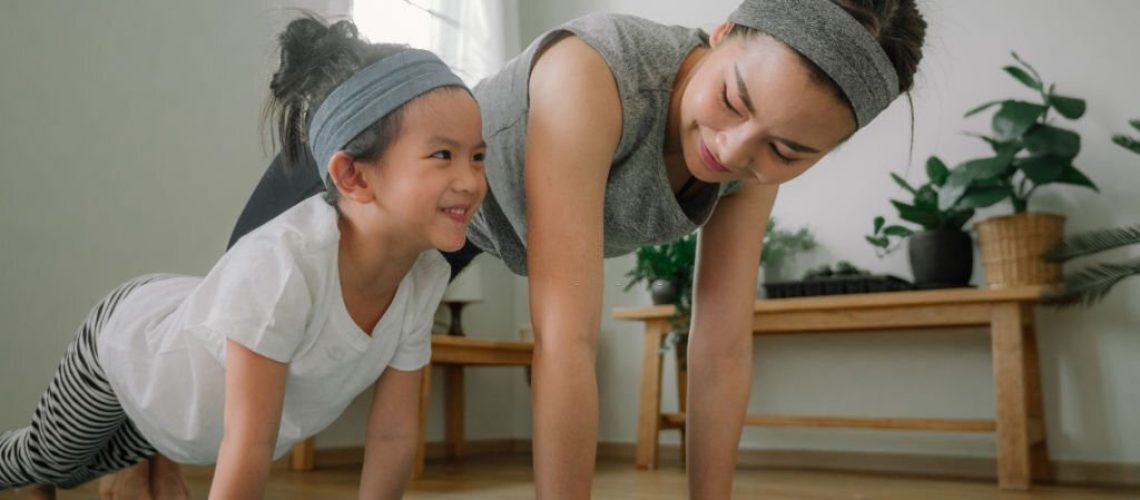 Sport young asian woman work out with little girl at home