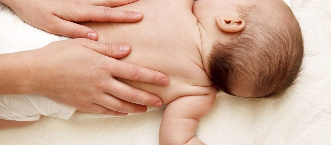 Masseuse massaging 5 months infant