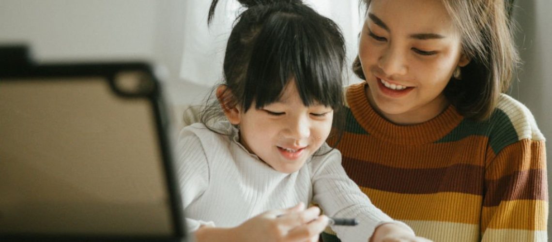 Asian mother and  daughter doing homework at home. The school has been closed during coronavirus outbreak and the classes have moved to e-learning platform.