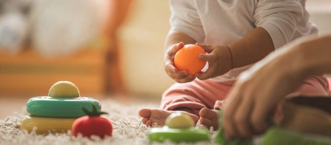 Cute baby girl playing in bedroom at home.