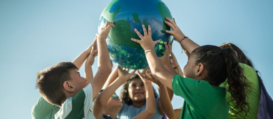 Children holding a planet outdoors