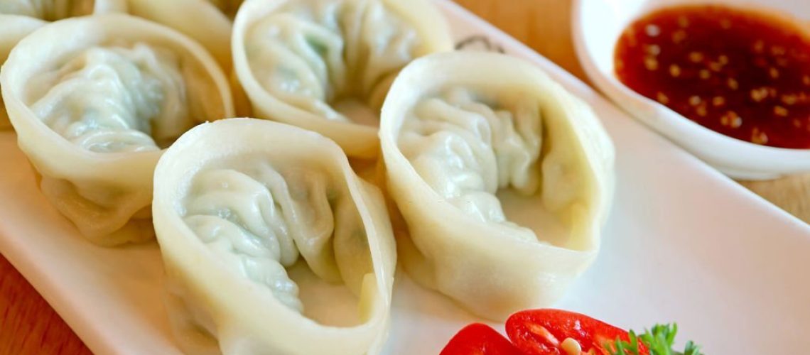 Closeup a Plate of Steamed Mandu or Korean Dumplings Served on Wooden Table