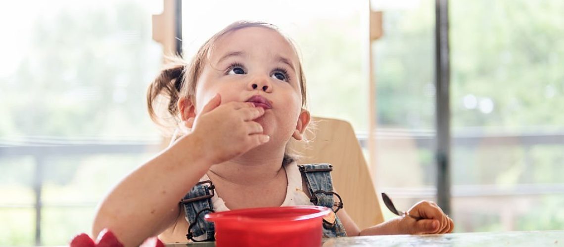 Little 2 years old girl eating jello